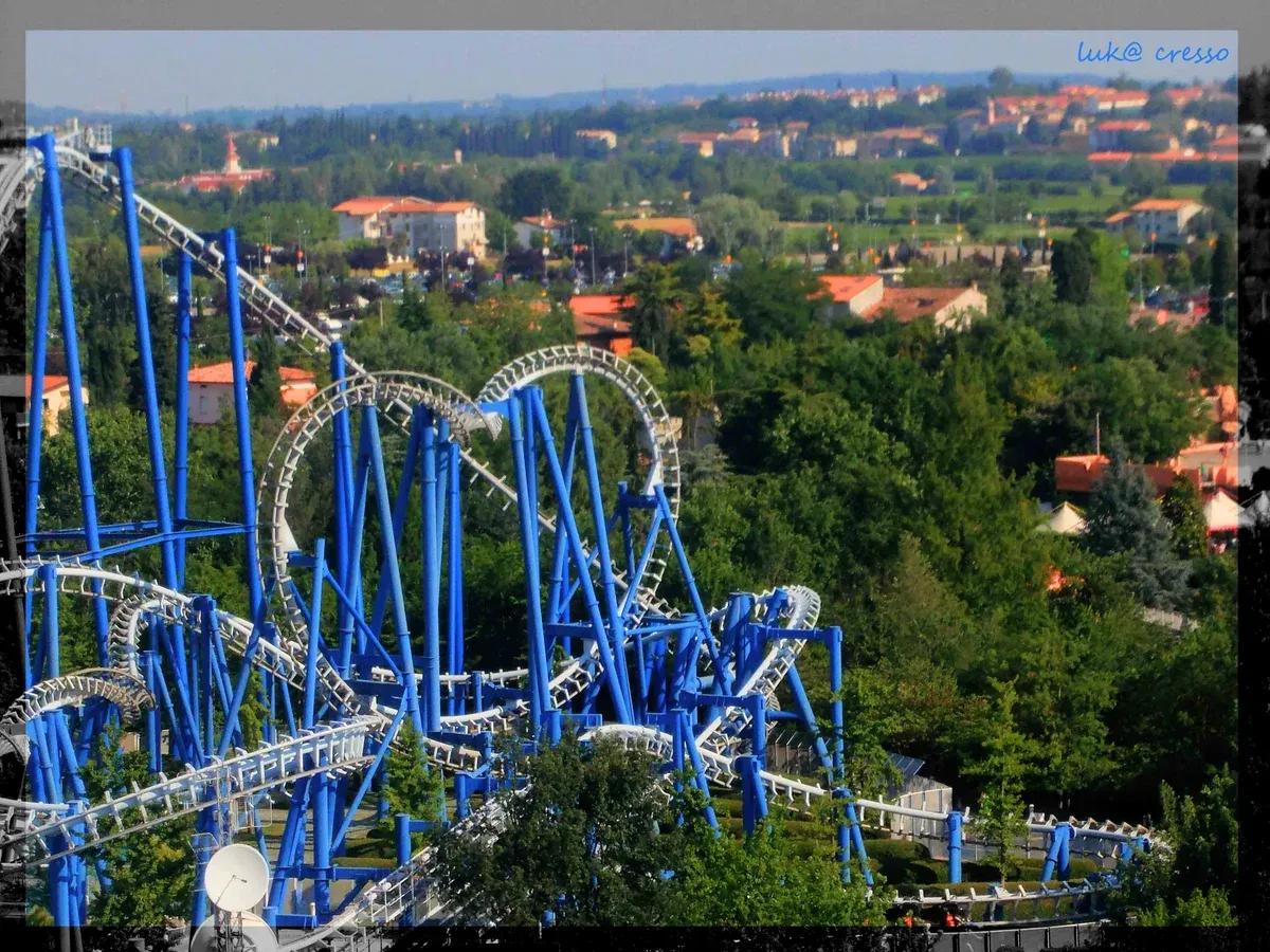 Blue steel loops of the Blue Tornado roller coaster above trees at Gardaland