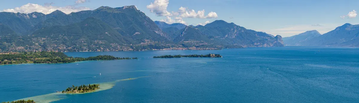 The gulf of Manerba with the islands of San Biagio and Isola del Garda, mountains behind