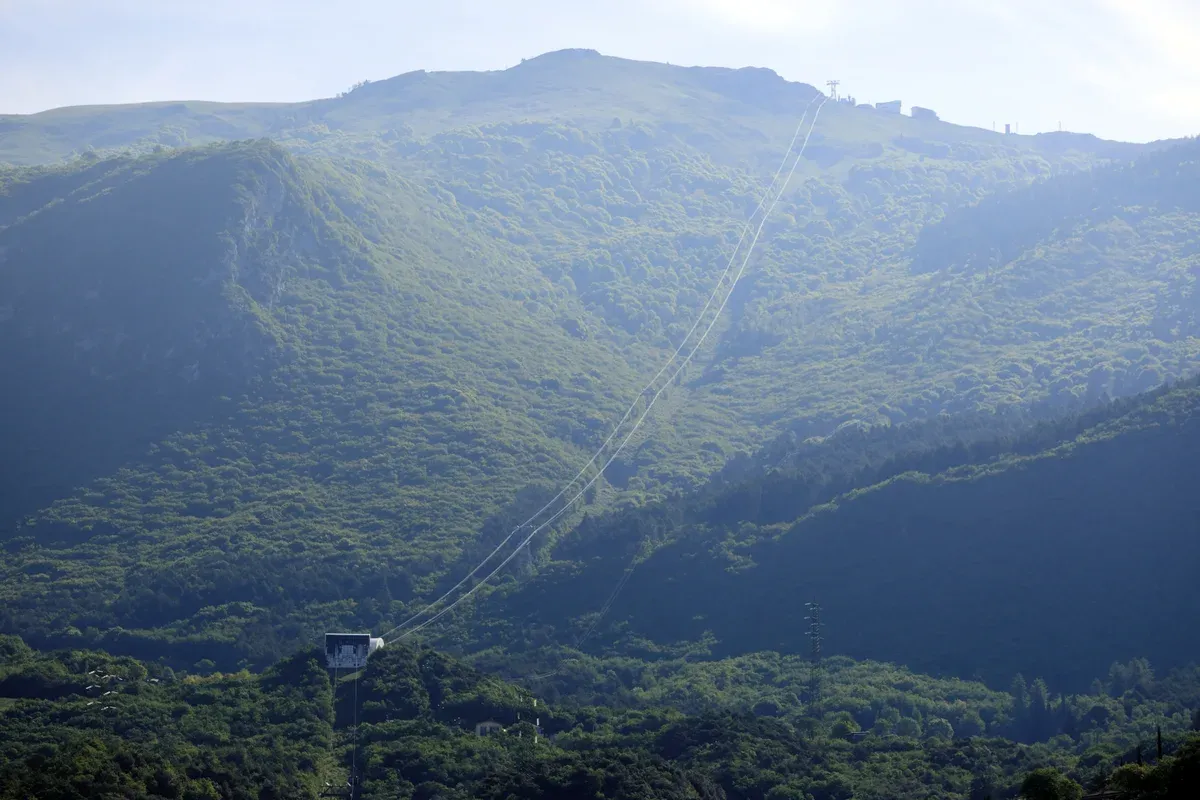 The Malcesine-Monte Baldo cable car line climbing a forested mountainside