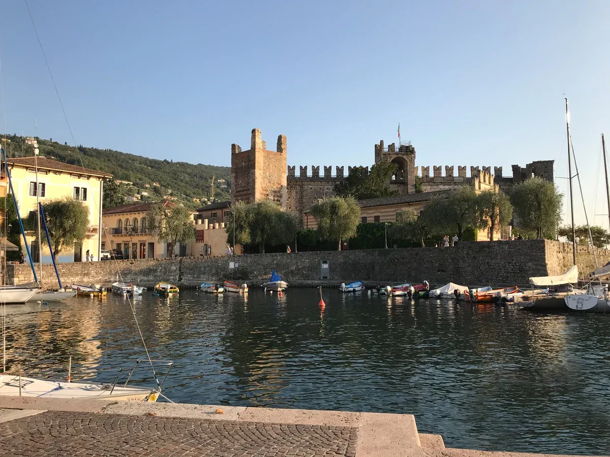 Torri del Benaco castle and its small harbor at golden hour